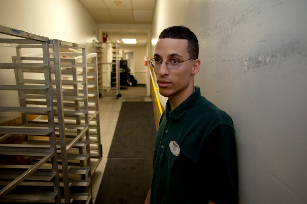 Man dressed in grocery store uniform poses for the camera