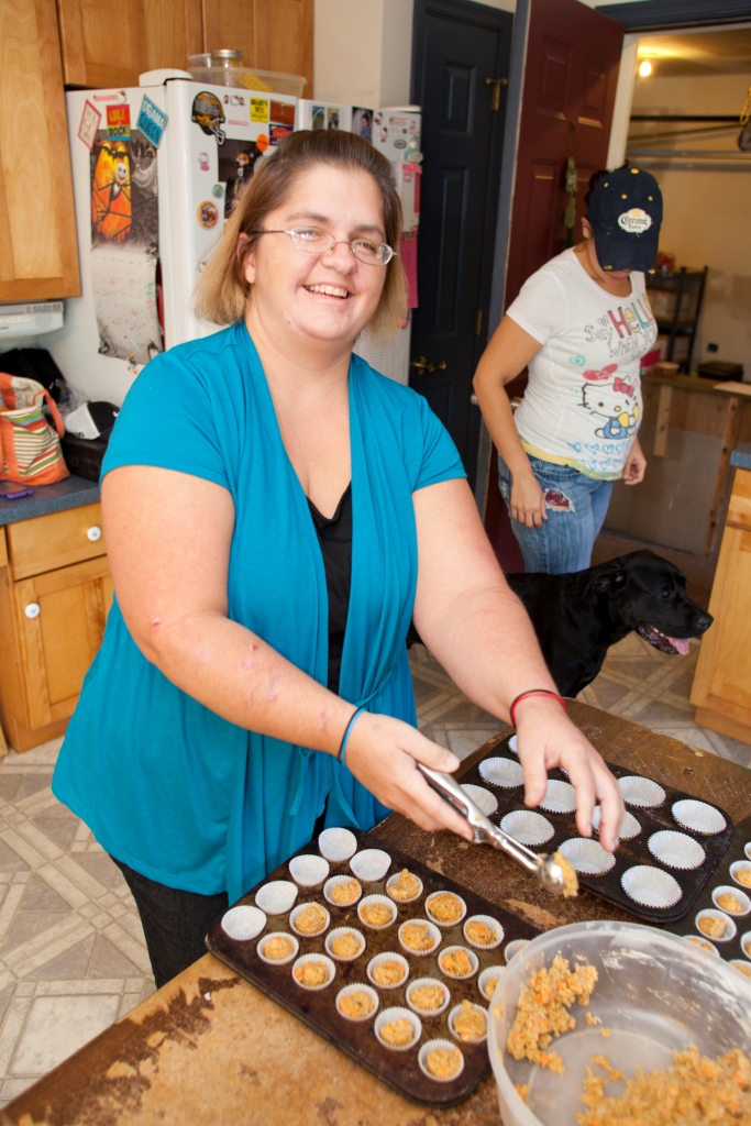 Woman prepares baked goods and smiles for the camera