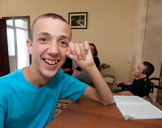 Young man sits at table and smiles for the camera